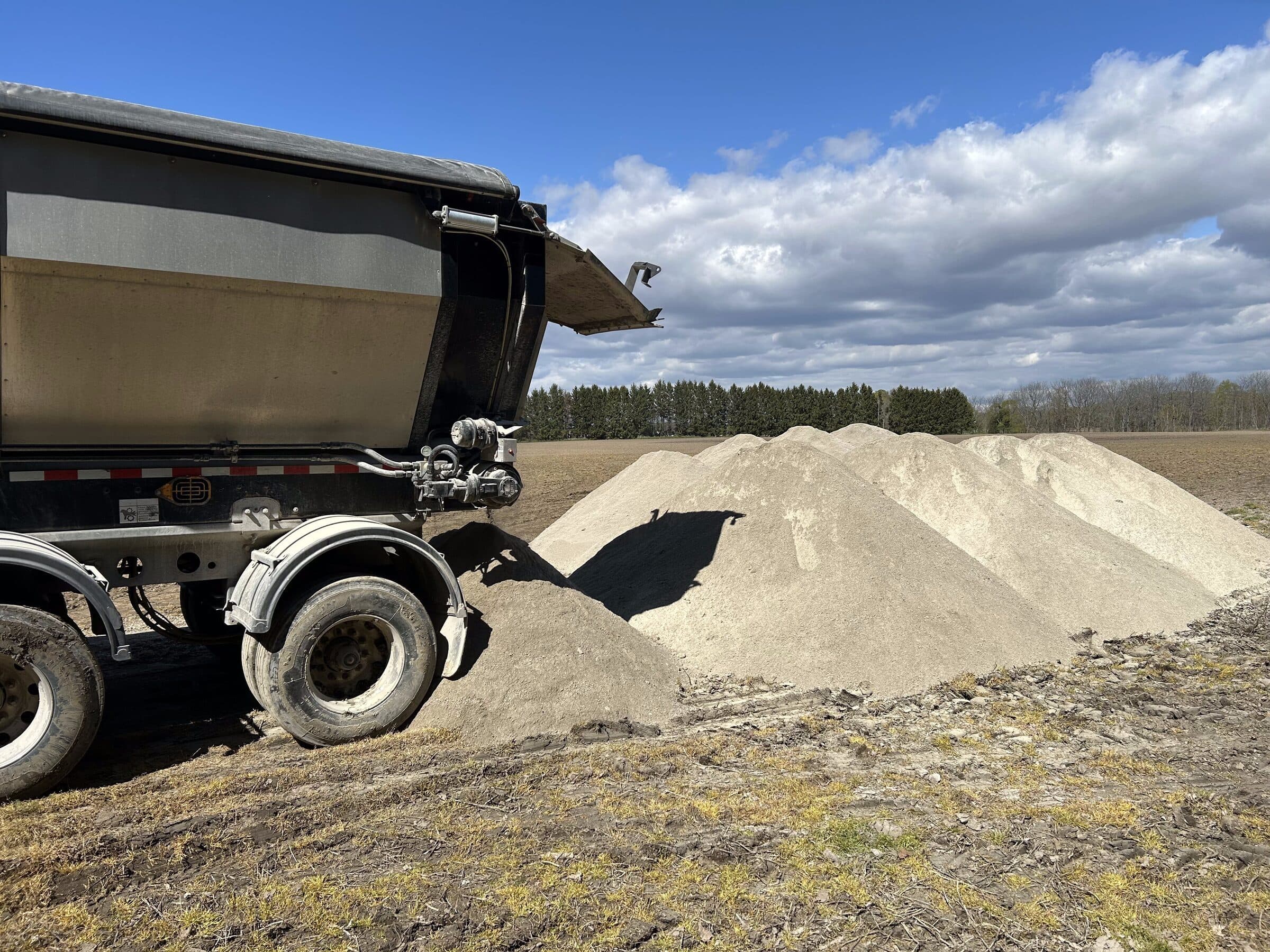 Dump truck delivering N-Rich fertilizer to a field pile in southwestern Ontario