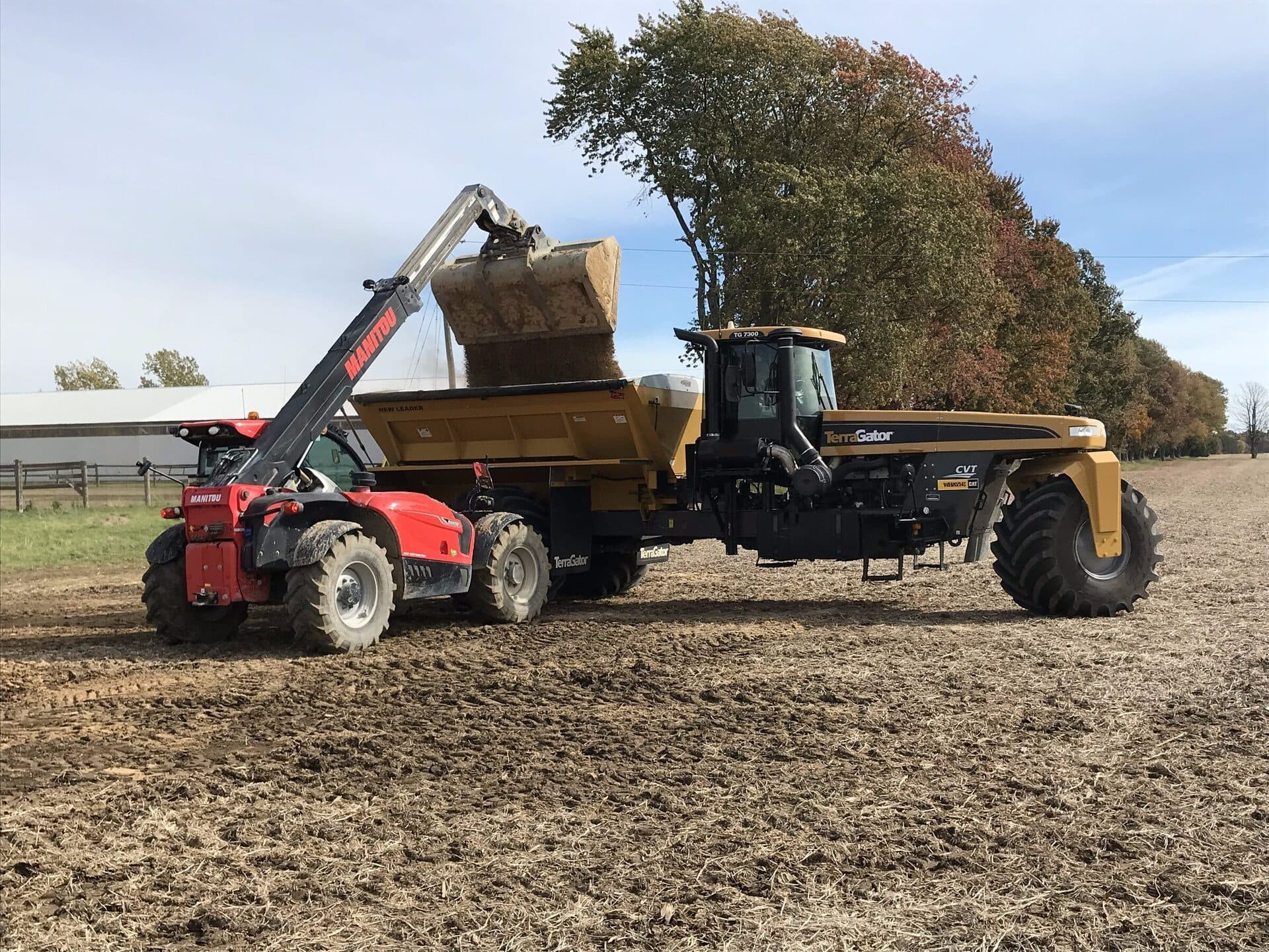 Telehandler loading N-Rich into a TerraGator floater spreader on an Ontario farm